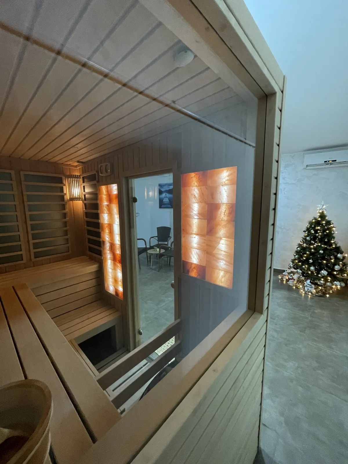 Glass-fronted sauna cabin with warm lighting